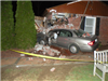 grey car crashed into brick house