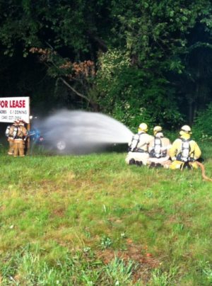 3 firefighters shooting water from hose