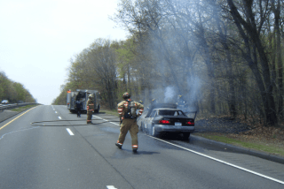 car smoking and fire fighter walking to it