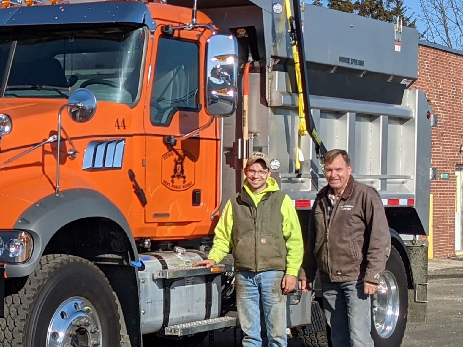 Orange Truck with two men standing next to it