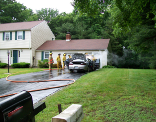 firefighters by a smoking car