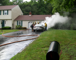firefighters by a smoking car