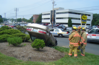 firefighter standing by upside down car