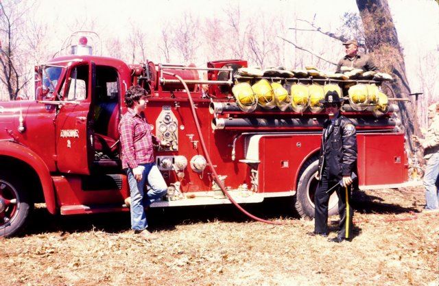 Two People Standing in Front of Red Fire Truck